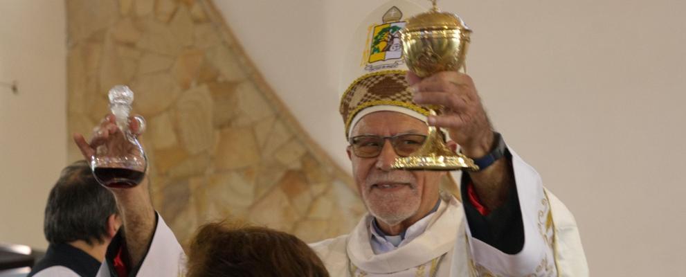 Der neu geweihte Bischof Miguel Fritz feiert seine erste Eucharistie als Bischof. Er hält den Kelch und ein Glaskännchen mit Wein empor und präsentiert die Gaben im Kirchenraum