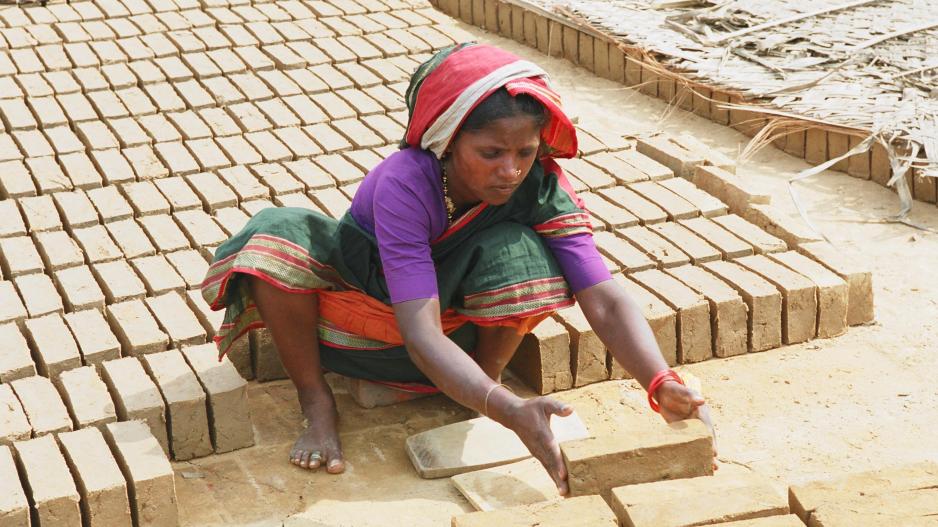 Ziegelfabrik an der Straße nach Mangalore, Indien Eine Frau stapelt handgeformte Ziegel